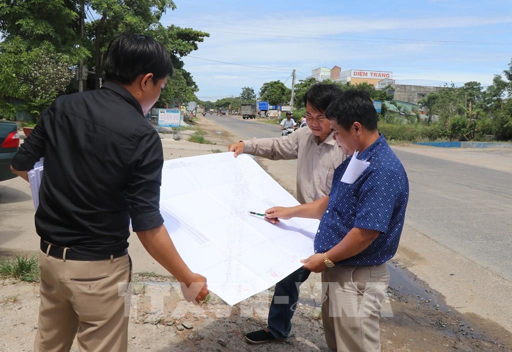Cán bộ Trung tâm phát triển quỹ đất huyện Phú Hòa thực hiện đo đạc, kiểm đếm lên phương án đền bù, bố trí tái định cư cho người dân xã Hòa An. Ảnh: Phạm Cường-TTXVN.