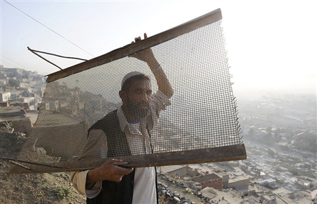 Ảnh một cư dân sinh sống trên sườn đồi Maina Jamal đang mang theo tấm lưới xuống trung tâm thành phố Kabul